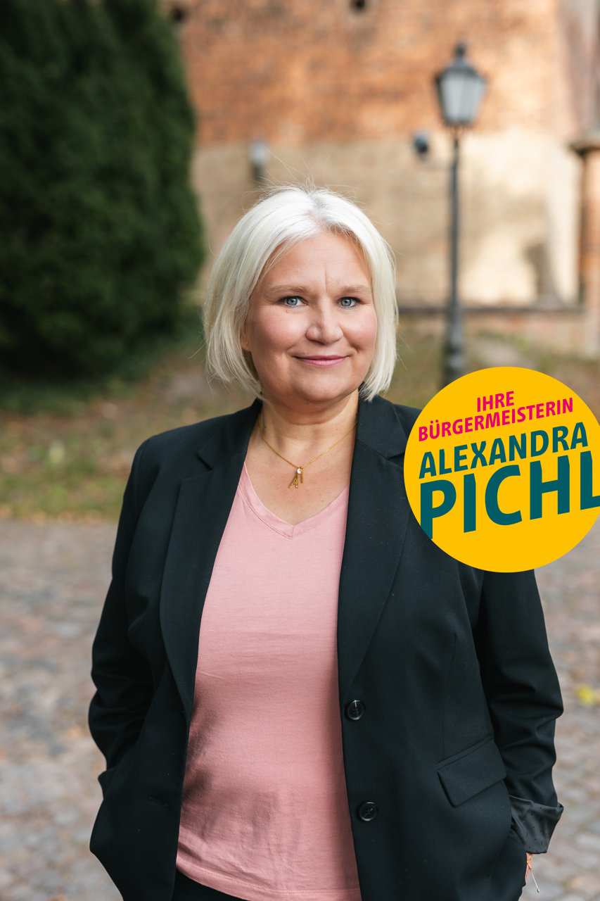 Unsere Bürgermeisterkandidatin Alexandra Pichl steht vor der Kirche im alten Dorf